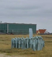 Billede af mindeparken for Jyllandsslaget i Thyborøn med bygninger i baggrunden
