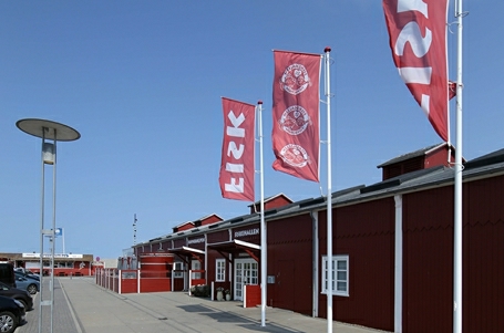 Billede af tre flagstænger udenfor den røde hal i Thyborøn